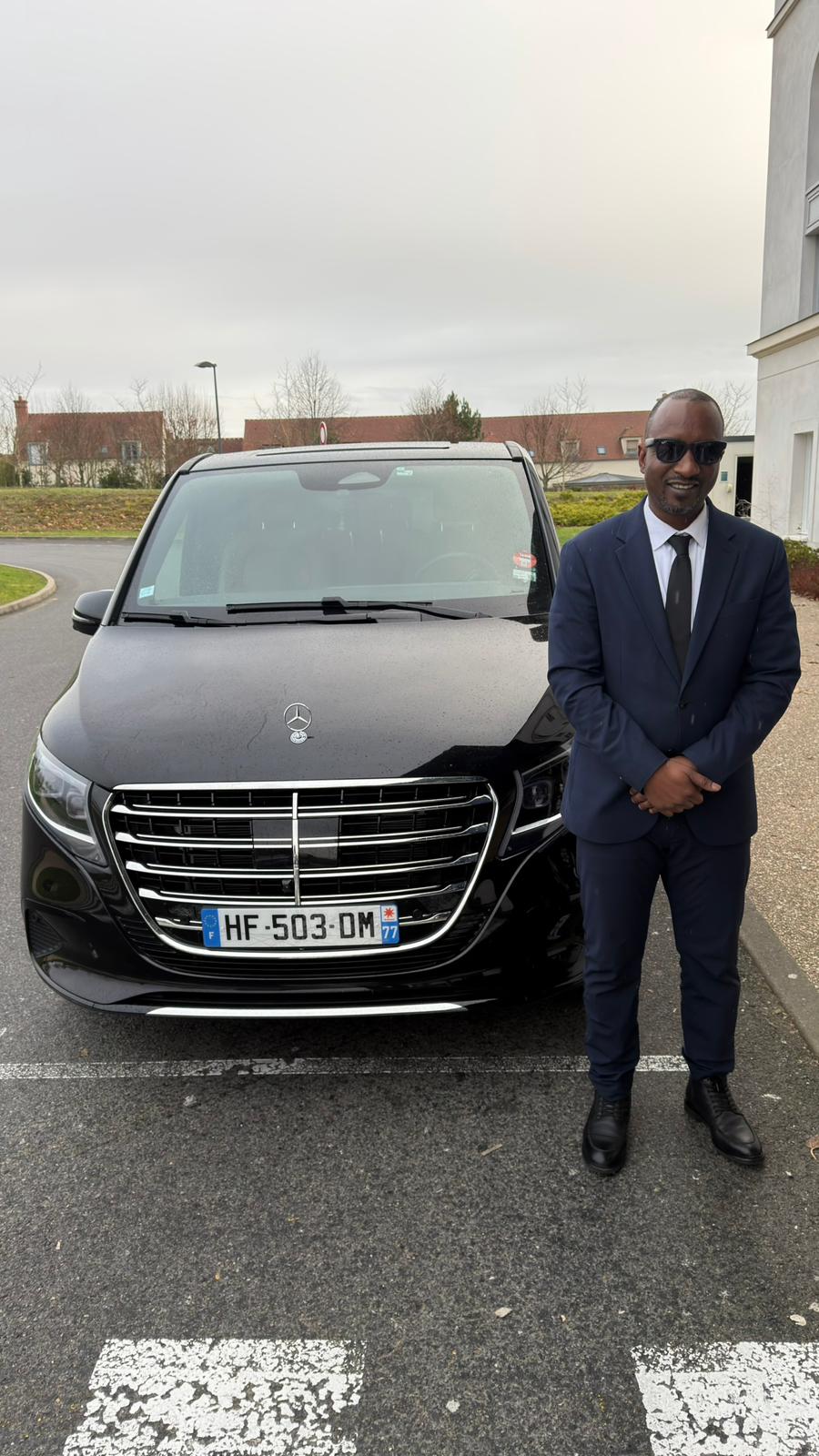 Chauffeur Nino Transport devant un véhicule Mercedes